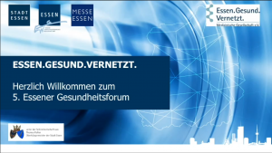 Begrüßungsfolie in Blautönen mit vernetzter Karten-Grafik und Stadtsilhouette. Text: ‚ESSEN.GESUND.VERNETZT. – Herzlich Willkommen zum 5. Essener Gesundheitsforum‘. Oben Logos von Stadt Essen, Essen.Wirtschaft, Messe Essen und ‚Essen.Gesund.Vernetzt. – Medizinische Gesellschaft e. V.‘; unten Hinweis: ‚unter der Schirmherrschaft von Thomas Kufen, Oberbürgermeister der Stadt Essen‘.