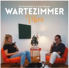 Auf dem Bild sitzen zwei Personen einander gegenüber auf orangefarbenen Sesseln in einem hellen Raum. Beide halten ein Mikrofon in der Hand und führen sichtbar ein Gespräch. Zwischen ihnen steht ein kleiner Tisch mit einer Pflanze und einem Aufnahmegerät. Auf dem Boden liegt ein schwarz-weißer Hund entspannt vor den Sesseln. Oben im Bild steht der Podcast-Titel „Wartezimmer Vibes“ und darunter die Namen „Kim Bumbullies & Julian Fellinger“.